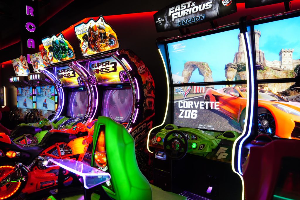Picture of multiple arcade games including fast & furious, super bikes and mario kart